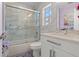 Modern bathroom with marble tile, a sliding glass door shower, and white vanity at 14485 Switch Back Rd, Brooksville, FL 34609