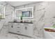 Elegant bathroom with double vanity, soaking tub, and marble tile at 14485 Switch Back Rd, Brooksville, FL 34609