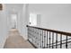 Upstairs hallway with carpet and a metal railing overlooking the staircase at 19803 Cypress Bridge Dr, Odessa, FL 33556