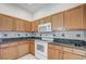 Kitchen with wood cabinets, granite countertops, and white appliances at 20743 Nectarine Pl, Land O Lakes, FL 34637