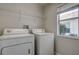 Bright laundry room with washer, dryer, and shelving at 20743 Nectarine Pl, Land O Lakes, FL 34637