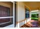 Covered front porch with tiled floor and screen door at 20743 Nectarine Pl, Land O Lakes, FL 34637