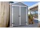 Gray storage shed with double doors and white trim at 3309 Bayport Dr, Holiday, FL 34691