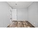 Bedroom with wood-look flooring and a door to another room of the house at 4304 Buena Vista Ln, Holiday, FL 34691