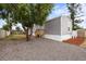 Exterior featuring gray siding with a new wooden deck, complemented by mature trees in the yard at 4304 Buena Vista Ln, Holiday, FL 34691
