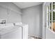Well-equipped laundry room with modern washer and dryer, storage, and exterior door at 4304 Buena Vista Ln, Holiday, FL 34691