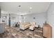Open-concept living room featuring modern furnishings, laminate floors, and ample natural light at 4304 Buena Vista Ln, Holiday, FL 34691