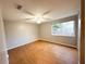 Simple bedroom with wood-look floors and a window at 6417 Sutherland Ave, New Port Richey, FL 34653
