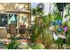 Landscaped backyard with mature trees, flowering plants, shrubs, and patio with a dining table at 8231 Coral Creek Loop, Hudson, FL 34667