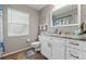 Bathroom featuring a white vanity with marbled countertops and decorative mirror at 8231 Coral Creek Loop, Hudson, FL 34667