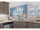 Stylish kitchen showcasing gray cabinets, marble countertops, stainless steel appliances, and pendant lighting at 8231 Coral Creek Loop, Hudson, FL 34667