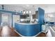 Bright kitchen with stainless steel appliances, a curved breakfast bar and pendant lighting at 8231 Coral Creek Loop, Hudson, FL 34667