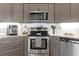 Well-equipped kitchen featuring stainless steel appliances, gray cabinetry, and modern finishes at 8231 Coral Creek Loop, Hudson, FL 34667
