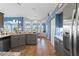 Open-concept kitchen with gray cabinets, an island, and views of the living and dining areas at 8231 Coral Creek Loop, Hudson, FL 34667