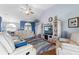 Comfortable living room with high ceilings, ceiling fan, and white leather seating at 8231 Coral Creek Loop, Hudson, FL 34667