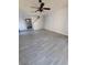 Spacious living room featuring wood-look tile, neutral walls, and a ceiling fan at 8733 Southern Charm Cir, Brooksville, FL 34613