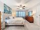 Main bedroom with large bed, dresser, and ocean-themed artwork at 16864 Red Brick Ln, Land O Lakes, FL 34638