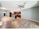 Open living room features wood-look floors, a ceiling fan, and an island kitchen at 1698 Hubbell Rd, Wesley Chapel, FL 33543