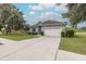 Gray house with a white garage door and driveway at 2293 Dog Leg Ct, Brooksville, FL 34604