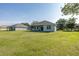 Generous backyard featuring a well-maintained lawn, screened-in patio, and ample space for outdoor activities at 2293 Dog Leg Ct, Brooksville, FL 34604