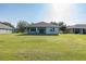 Expansive backyard featuring a covered patio, lush green lawn, and a serene outdoor living space at 2293 Dog Leg Ct, Brooksville, FL 34604