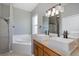 Bright bathroom featuring double sinks, a soaking tub and walk-in shower at 2293 Dog Leg Ct, Brooksville, FL 34604