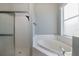Bright bathroom featuring a walk-in shower and soaking tub near a window at 2293 Dog Leg Ct, Brooksville, FL 34604