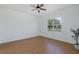 Well-lit bedroom featuring wood-look floors, ceiling fan, and a large window at 2293 Dog Leg Ct, Brooksville, FL 34604
