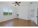 Well-lit bedroom featuring wood-look floors, ceiling fan, and a large window at 2293 Dog Leg Ct, Brooksville, FL 34604