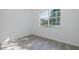 A well-lit room featuring a large window and light gray wood-look floors at 2293 Dog Leg Ct, Brooksville, FL 34604