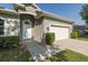 Close up of a charming entrance, featuring a two-car garage, neat landscaping, and welcoming walkway at 2293 Dog Leg Ct, Brooksville, FL 34604
