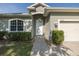 Close up of a charming entrance, featuring neat landscaping, a welcoming walkway and an arched window at 2293 Dog Leg Ct, Brooksville, FL 34604