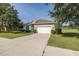 Single-story home with a long driveway, two-car garage, manicured lawn and landscaping at 2293 Dog Leg Ct, Brooksville, FL 34604