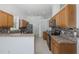 Modern kitchen features wood cabinets, granite countertops, stainless steel appliances, and decorative backsplash at 2293 Dog Leg Ct, Brooksville, FL 34604