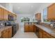 Modern kitchen features wood cabinets, granite countertops, stainless steel appliances, and decorative backsplash at 2293 Dog Leg Ct, Brooksville, FL 34604
