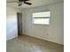 Small, sunny bedroom features tile floors, a ceiling fan, and a window with blinds at 4913 Hazner St # 4913, New Port Richey, FL 34652