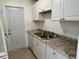 Updated kitchen features granite countertops, white cabinets, stainless sink, and a modern door at 4913 Hazner St # 4913, New Port Richey, FL 34652