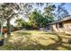 Large backyard with a spacious lawn and wooden deck at 6084 Pinehurst Dr, Spring Hill, FL 34606