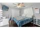 This bedroom boasts a ceiling fan, wood-look flooring, and a wall-mounted television at 6450 Trade Ct, Spring Hill, FL 34606