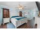 This bedroom features a large bed with a ceiling fan and wood-look floors at 6450 Trade Ct, Spring Hill, FL 34606