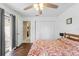 This cozy bedroom features wood-look flooring, a ceiling fan, and a private patio entrance at 6450 Trade Ct, Spring Hill, FL 34606