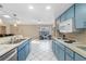 Bright kitchen with blue cabinets, white countertops, and matching tile floors offers ample counter space at 6450 Trade Ct, Spring Hill, FL 34606