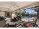 Covered outdoor patio with ceiling fans and a view of the sparkling pool at 6450 Trade Ct, Spring Hill, FL 34606