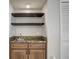 Wet bar with granite countertop, wooden cabinets, and two shelves at 7499 Heather Walk, Weeki Wachee, FL 34613