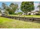 Landscaped backyard with a wooden fence and mature trees at 7499 Heather Walk, Weeki Wachee, FL 34613