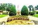 Welcoming Heather Walk entrance with lush landscaping and an American flag at 7499 Heather Walk, Weeki Wachee, FL 34613