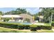 Community pool surrounded by lounge chairs, umbrellas, and lush landscaping at 7499 Heather Walk, Weeki Wachee, FL 34613