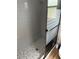 Gray tiled shower with a frameless glass door at 8353 Forest Oaks Blvd, Spring Hill, FL 34606