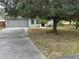 House exterior with gray garage door and driveway at 8353 Forest Oaks Blvd, Spring Hill, FL 34606