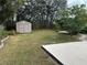 Large backyard with storage shed and lush landscaping at 8353 Forest Oaks Blvd, Spring Hill, FL 34606